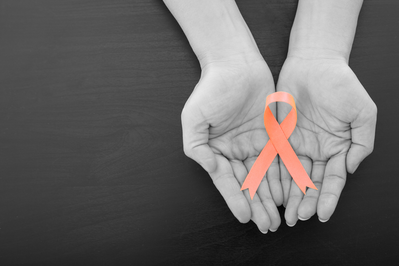 hands holding peach ribbon for endometrial cancer