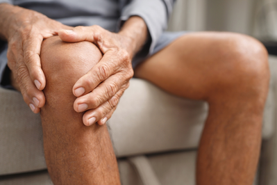 older man holding arthritic knee