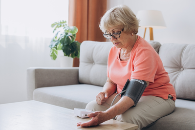 older woman measuring her blood pressure at home