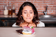 woman looking longingly at plate of desserts