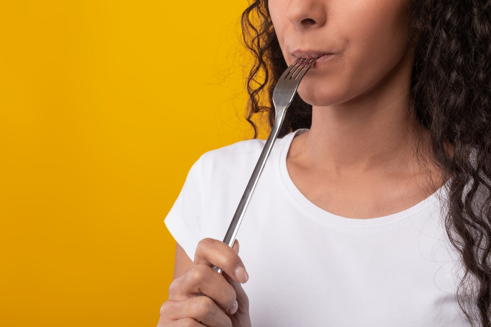 woman biting fork