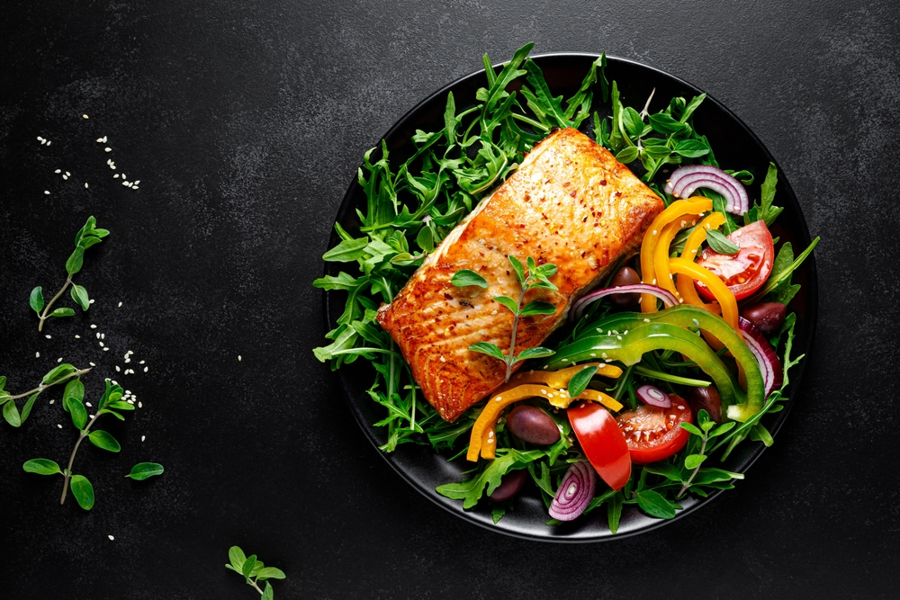 salmon served with vegetables and greens